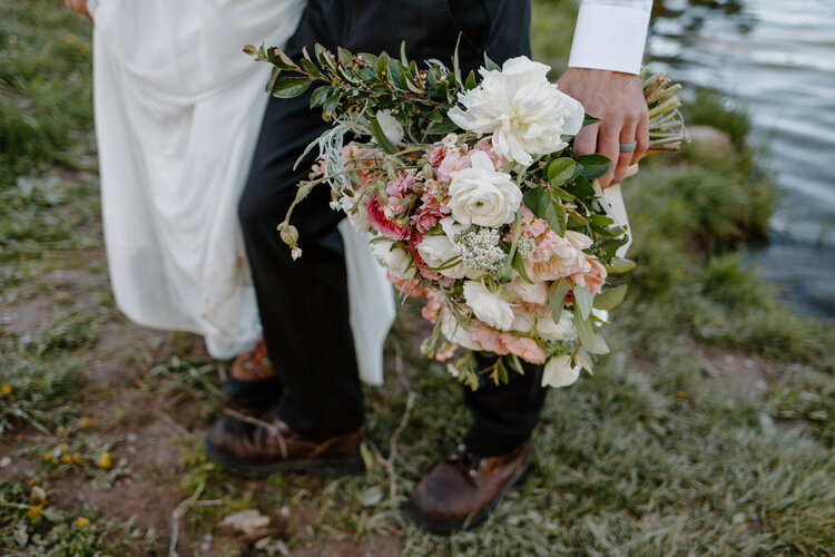 Groom holds a pink and blush tone bouquet