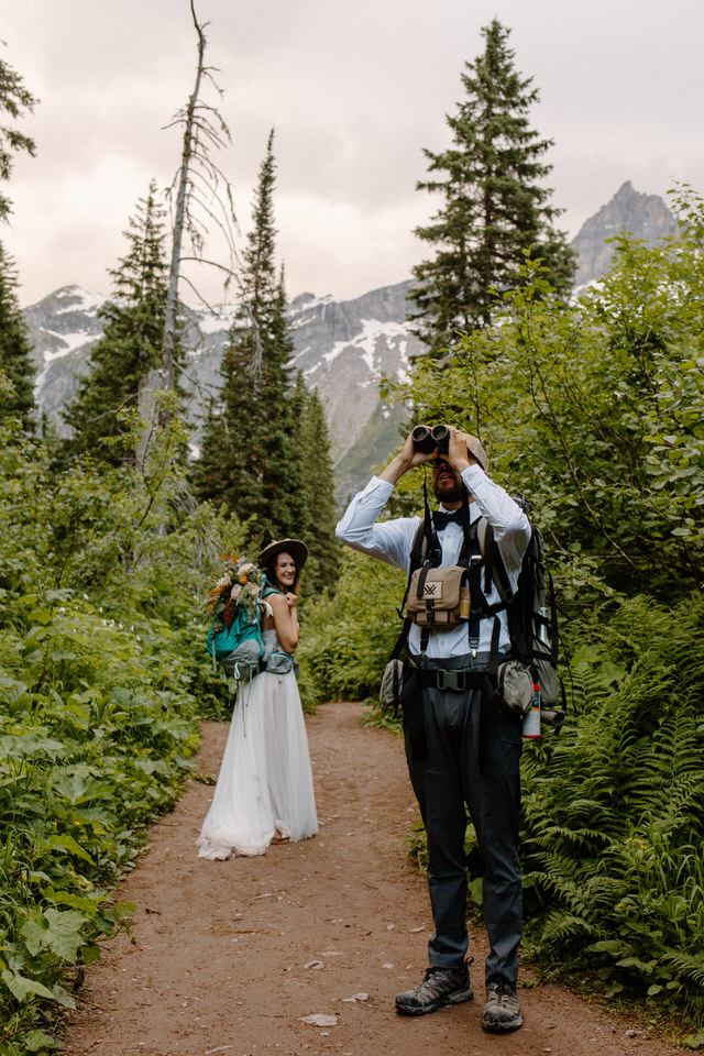 groom looks through binoculars in montana