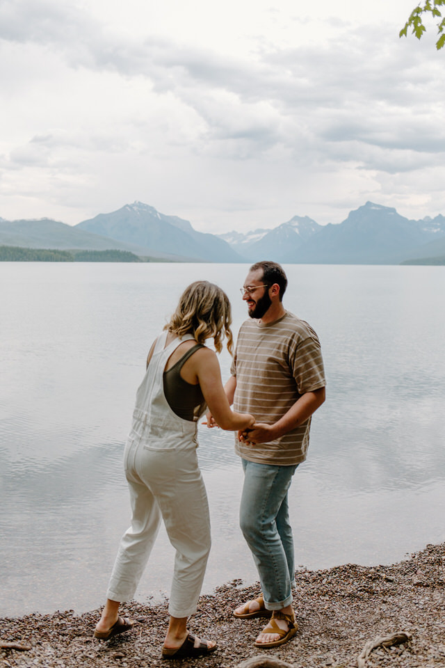 couple holds hands in glacier national park