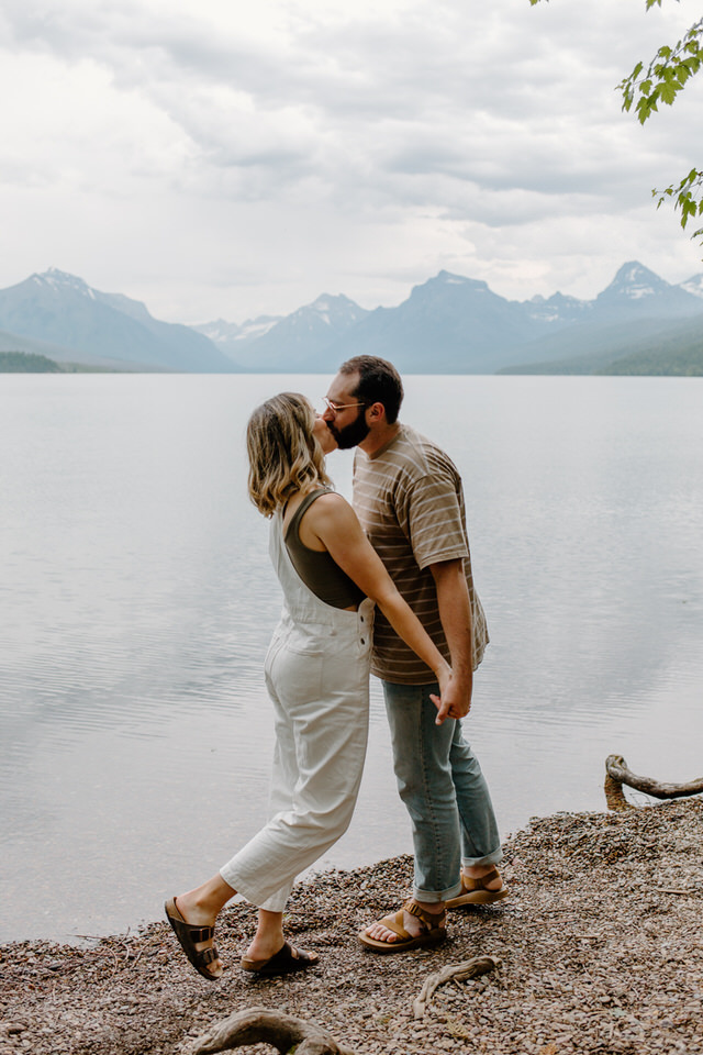 couple kisses in front of lake mcdonald montana