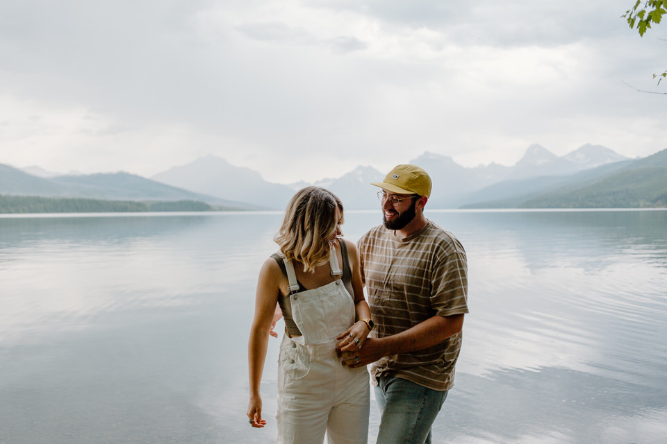 engaged couple holds hand at glacier national park