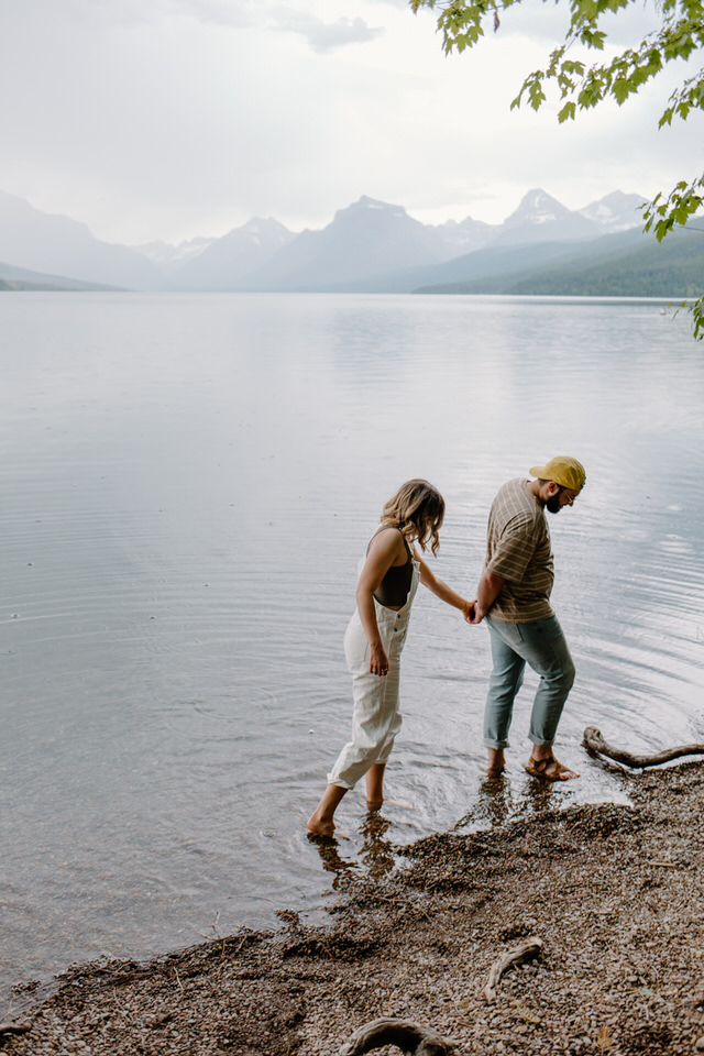 couple holds hands at glacier national park