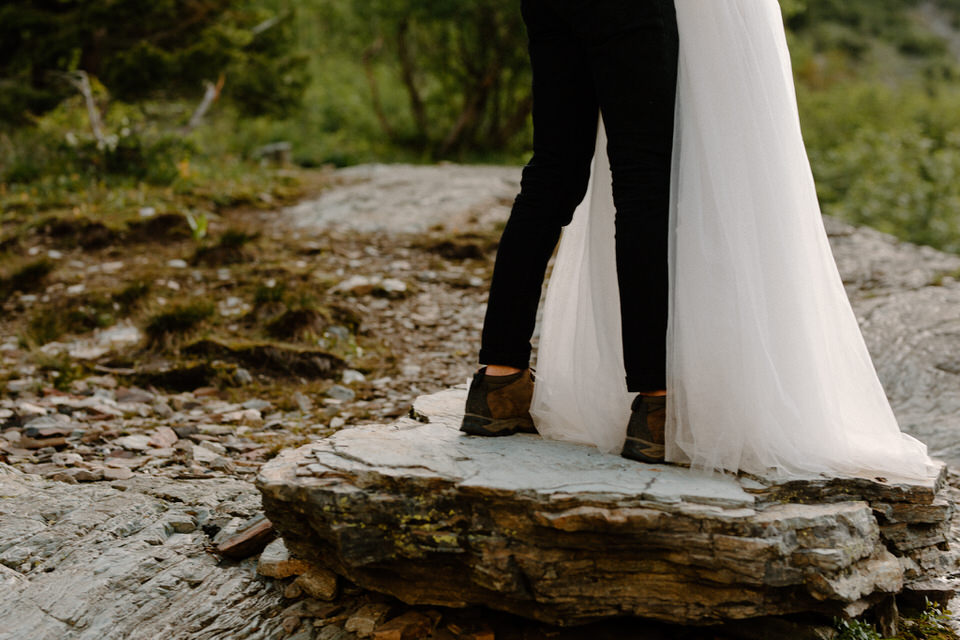 eloping couple stands on boulder in leigh lake
