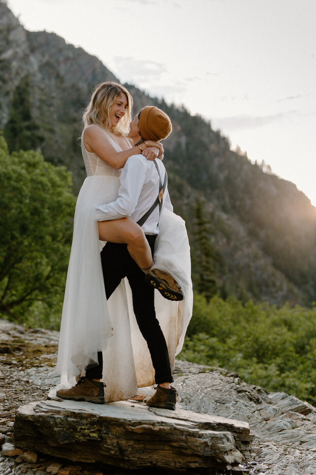 eloping couple hugs in front of mountain