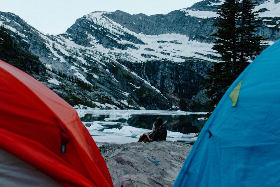 couple sits between tents in montana
