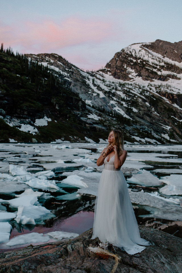 eloping bride puts on necklace at sunrise in montana
