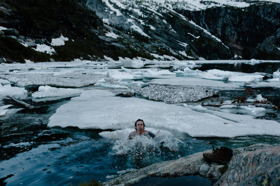 grooms swims in glacial lake