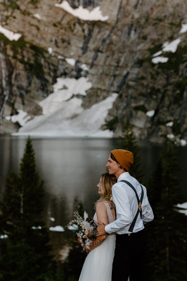 bride and groom look at leigh lake montana
