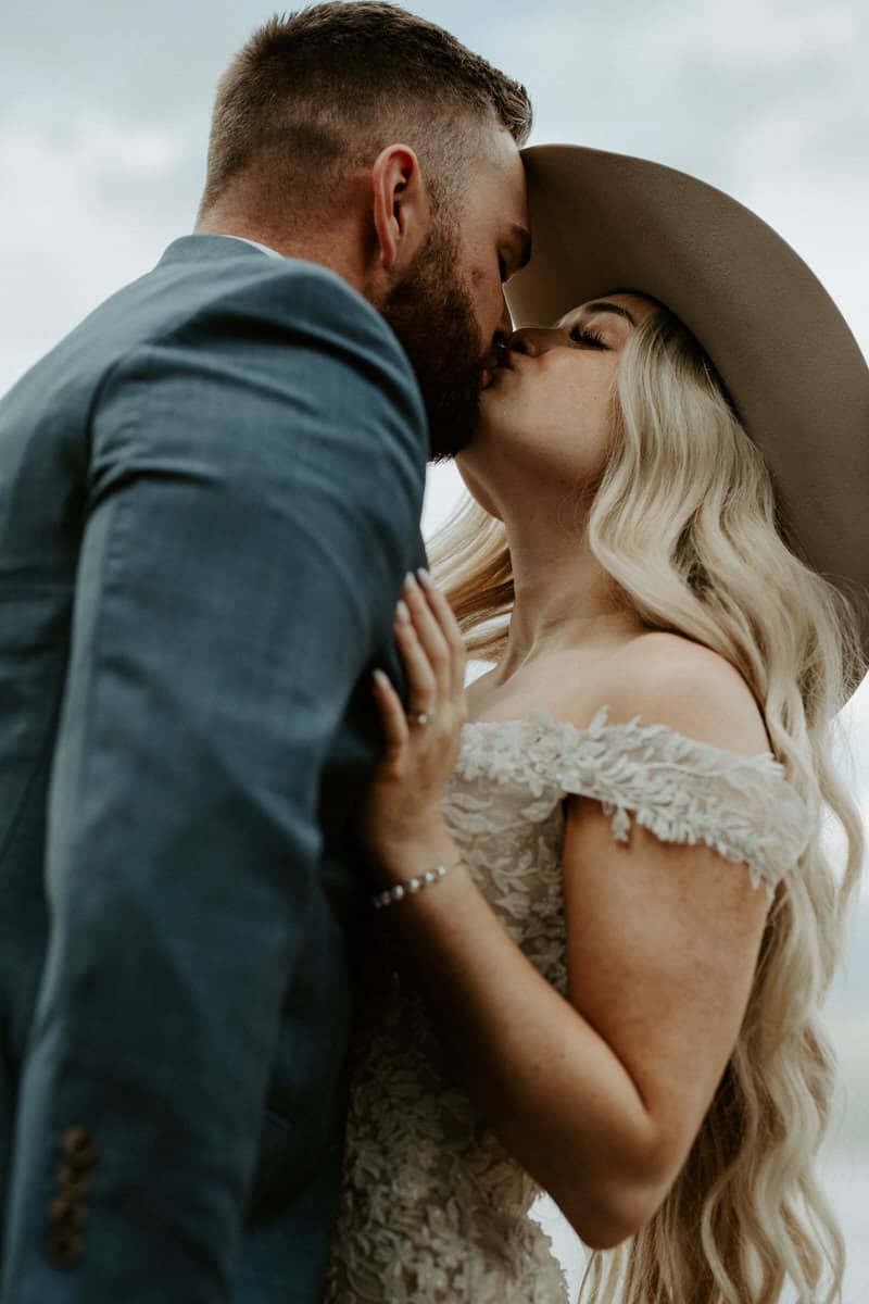 newlyweds kiss with cowboy hats